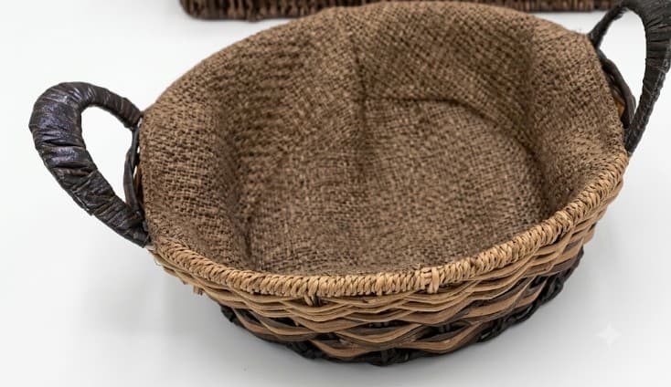 CANASTA TEJIDA OVALADA CON ASAS CUBIERTA CON TELA MARRON 24X7CM